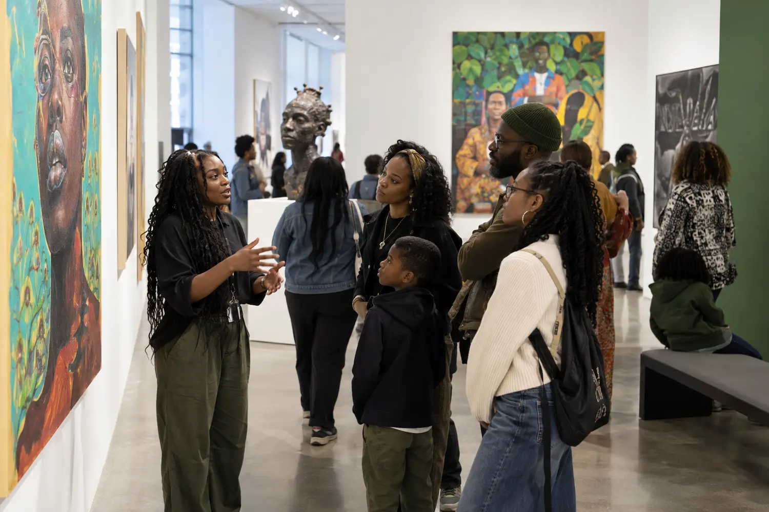 Black artists, students and families gathering inside a contemporary museum gallery
